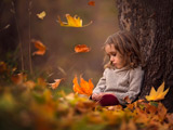دختر بچه غمگین زیر درخت پاییزی
